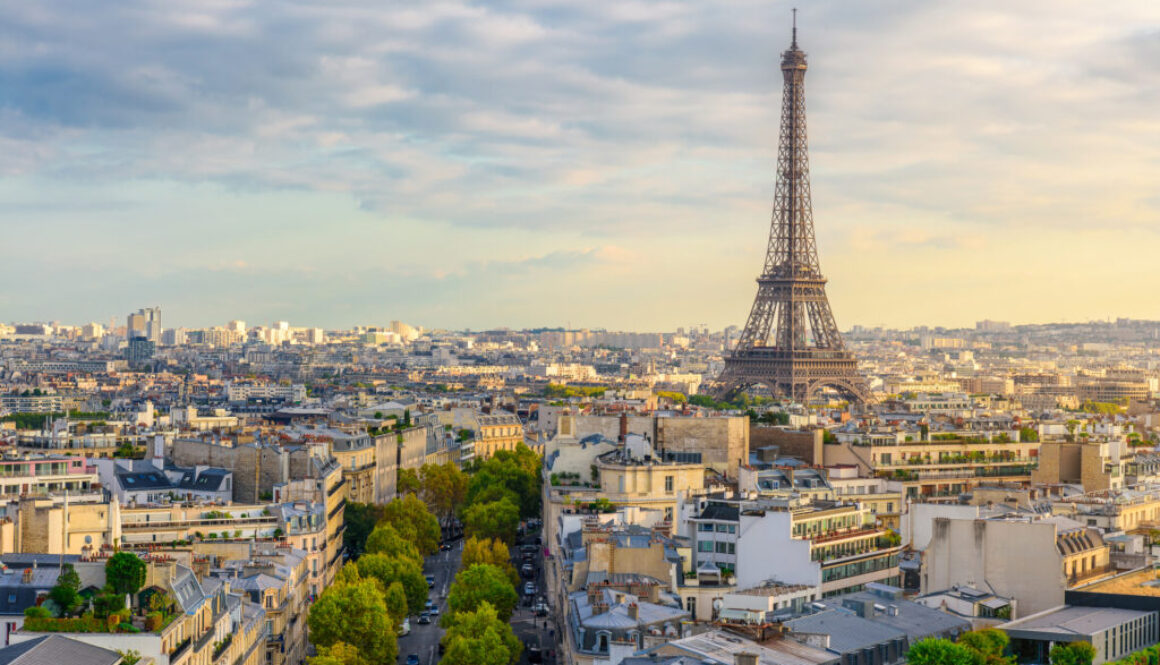 Aerial view of Paris with Eiffel Tower and Champs Elysees from the roof of the Triumphal Arch. Panoramic sunset view of old town of Paris. City skyline. Popular travel destination