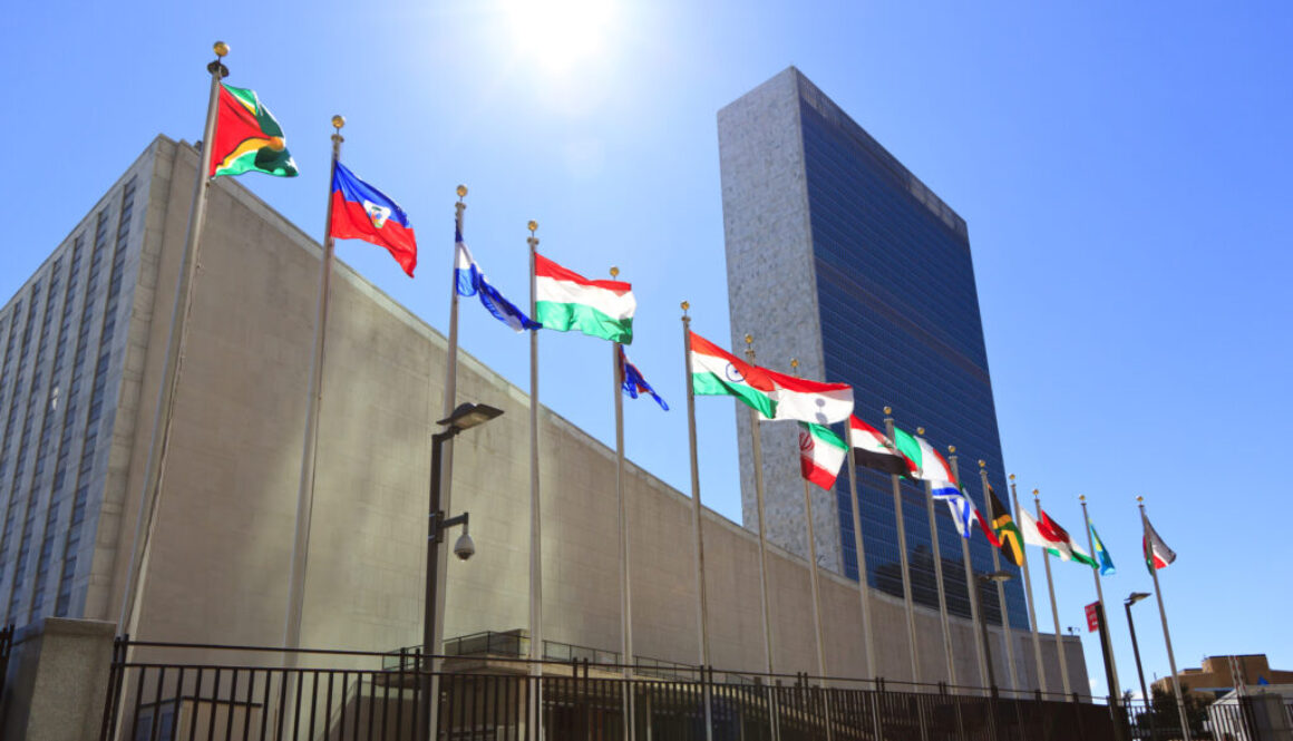 United Nations Headquarters with waving flags in New York, USA