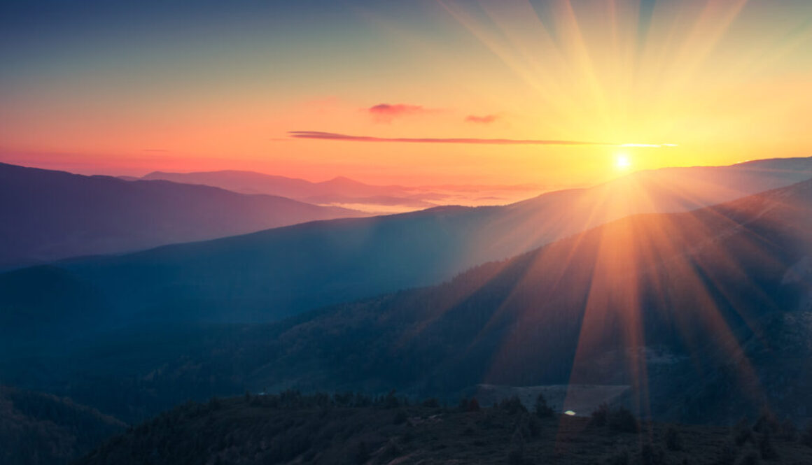 Panoramic view of colorful sunrise in mountains.