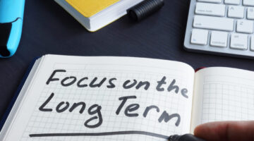 Man is writing focus on the long term.