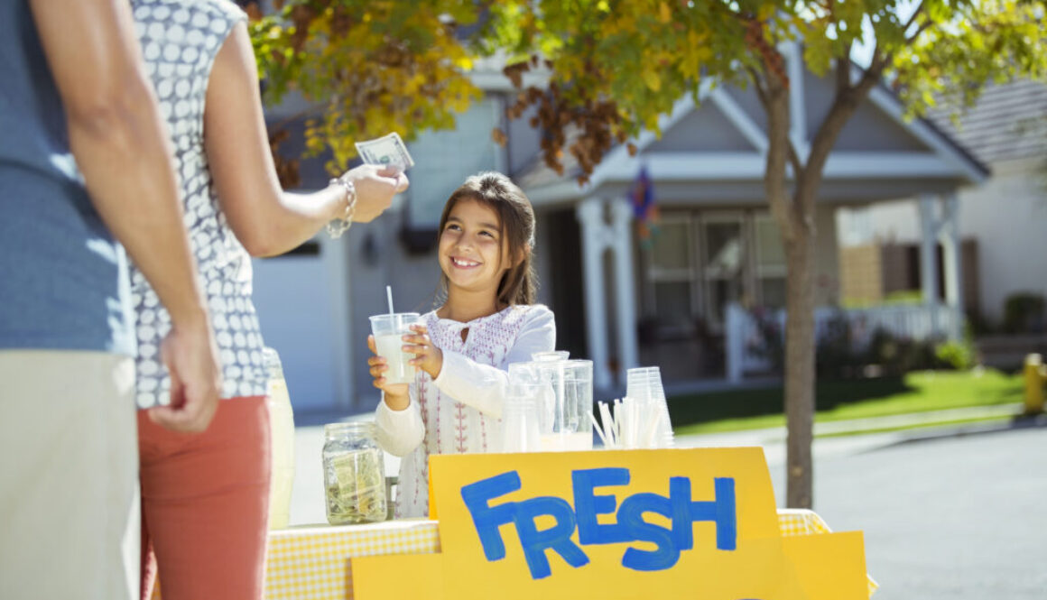 Girl selling lemonade at lemonade stand