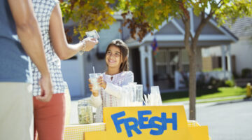 Girl selling lemonade at lemonade stand
