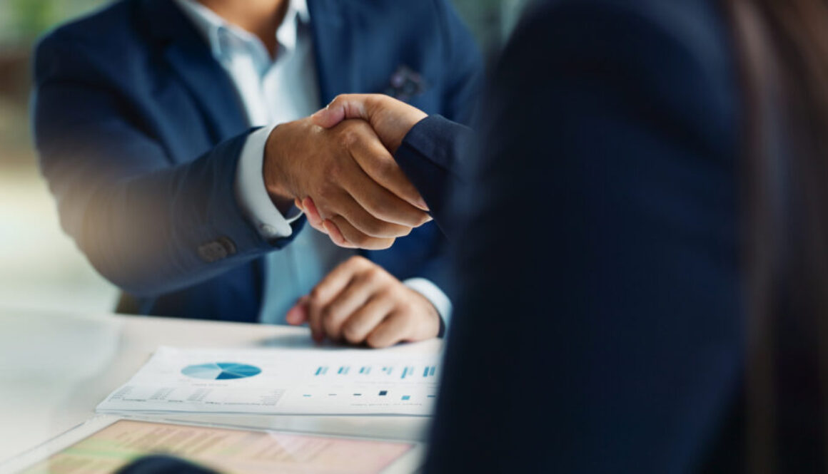 Business people, negotiation and handshake for deal, agreement or partnership in office. Shaking hands, closeup and hiring offer for recruitment, b2b collaboration or data analyst at table in meeting