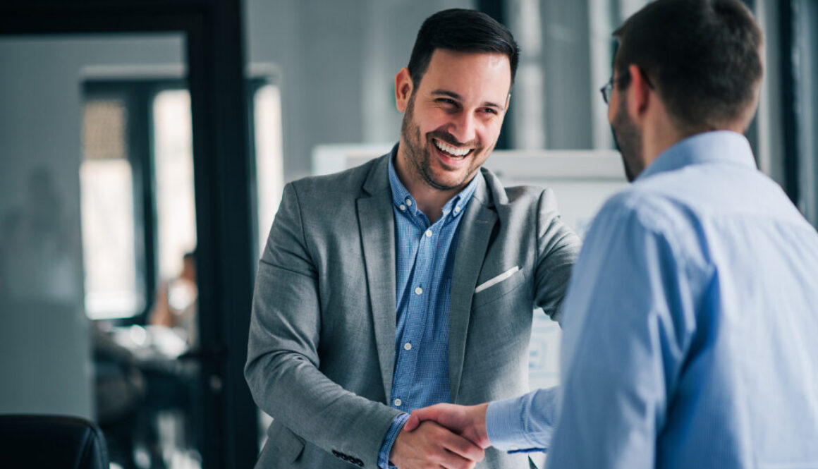 Portrait of cheerful young manager handshake with new employee.