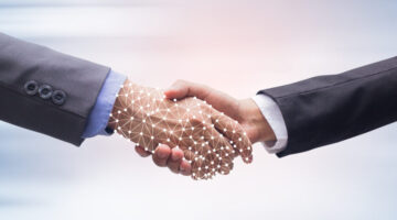close up business man handshake with business artificial intelligence (AI) on motion blur background for future technology concept