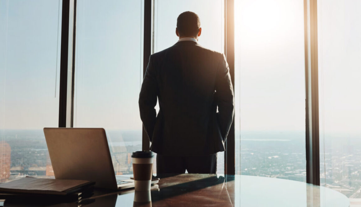 Business, man and back thinking at window in office with city view for legal case ideas and solution. Law firm, thoughtful advocate and professional or contemplating client defense for court trial