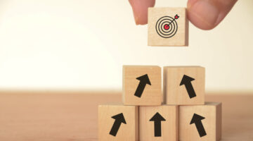 The image of a target block atop arrows suggests a clear path toward achieving goals.