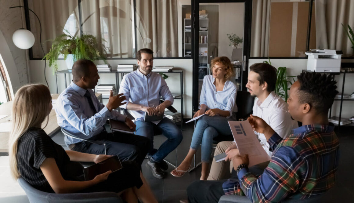 Multiethnic business team coworkers sitting in circle in office
