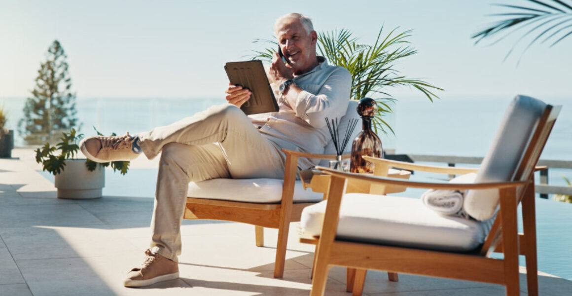 Phone call, tablet and relax with man at swimming pool for remote work, resort critic and customer feedback. Reading, freelancer and hospitality review with mature person at villa for luxury travel Leaders on How They Actually Disconnect on Vacation: Elliott Broidy in Fast Company
